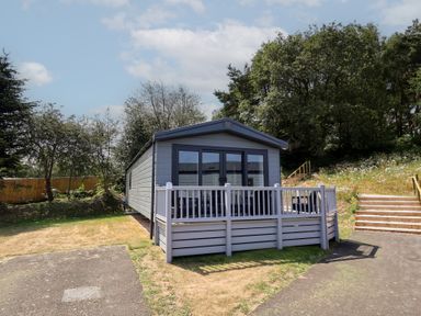 A mobile home with a deck and steps outside at The Pines 2 Bedrooms Delamere