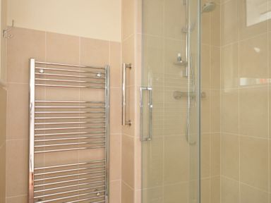 A bathroom with a shower and a towel rail at 42 Little Trelyn in Wadebridge