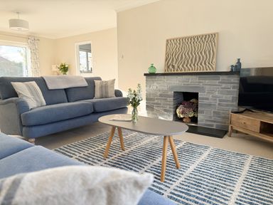 A living room with a sofa, coffee table, and television at 42 Little Trelyn in Rock