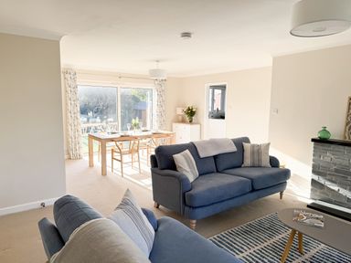 A living room with a sofa and dining area at 42 Little Trelyn in Rock