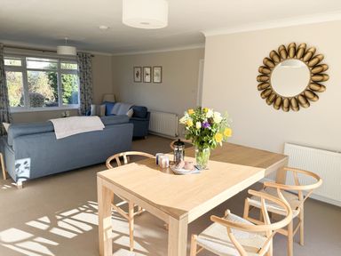 A living room with a sofa and dining table at 42 Little Trelyn in Rock