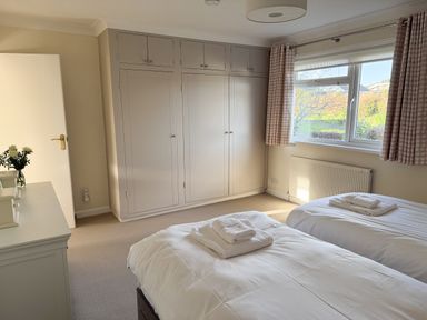 A bedroom with two beds and a wardrobe at 42 Little Trelyn in Rock