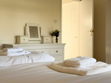 A bedroom with towels on the bed and a dressing table at 42 Little Trelyn in Rock