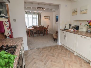 A kitchen leading to a dining area with a table and chairs at Iveridge Sandsend