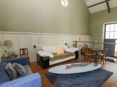 A sitting room with sofas a coffee table and a dining table at Zoar Chapel in Carew