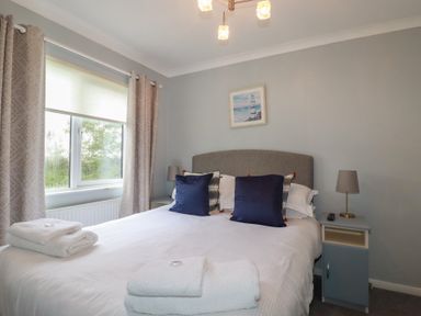 A bedroom with a double bed and window at Lodge 9 - Lamorna Tregolds near St Merryn