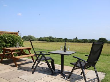 An outdoor seating area with chairs and a table at Honeypot Hideaways - Acacia