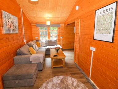 A living room with a sofa and coffee table at Stumps Cross Lodge in Upper Coscombe near Winchcombe