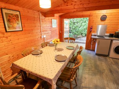 A dining room with a table and chairs at Stumps Cross Lodge in Upper Coscombe near Winchcombe