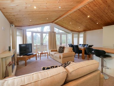 A living room with a television and sofa at Wansfell 2 in Limefitt Park near Troutbeck