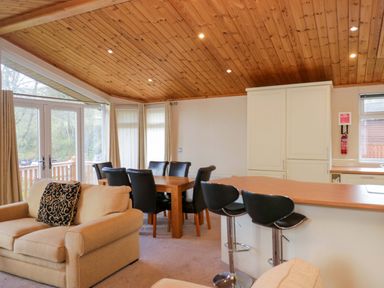 A living room with a dining table and chairs at Wansfell 2 in Limefitt Park near Troutbeck