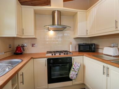 A kitchen with a cooker, microwave, and kettle at Wansfell 2 Limefitt Park near Troutbeck
