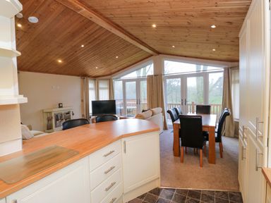 A living room with a dining area and television at Wansfell 2 in Limefitt Park near Troutbeck
