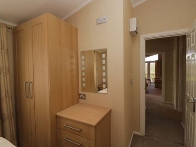 A bedroom with a wardrobe and chest of drawers at Wansfell 2 in Limefitt Park near Troutbeck