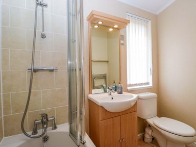 A bathroom with a shower, sink and toilet at Wansfell 2 Limefitt Park near Troutbeck