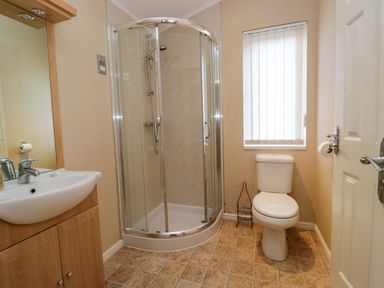 A bathroom featuring a shower, toilet, and sink at Wansfell 2 Limefitt Park near Troutbeck