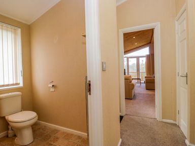A bathroom with a toilet and doorway leading to a living room at Wansfell 2 Limefitt Park near Troutbeck