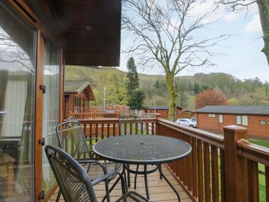An outdoor area with a table and chairs at Wansfell 2 Limefitt Park near Troutbeck