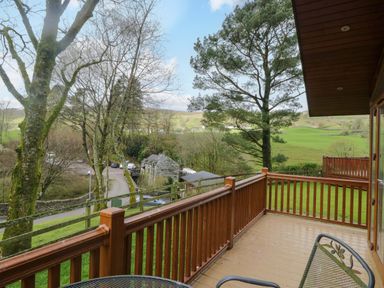 A view of trees and a road from a deck at Wansfell 2 Limefitt Park near Troutbeck