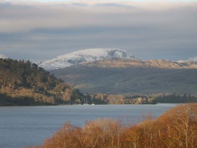 A view of a lake surrounded by mountains and trees at Wansfell 2 Limefitt Park near Troutbeck