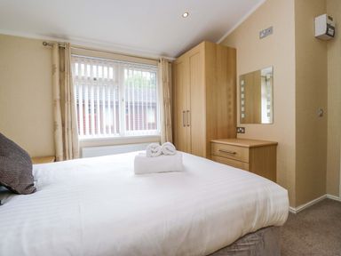 A bedroom with a bed and wardrobe at Wansfell 2 Limefitt Park near Troutbeck