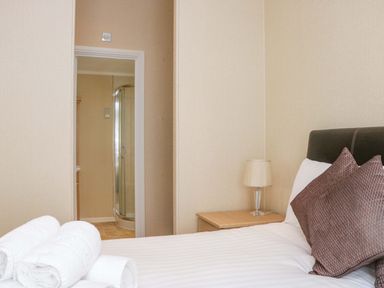 A bedroom with a bed and towels at Wansfell 2 in Limefitt Park near Troutbeck