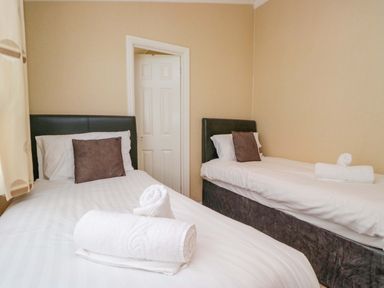 A bedroom with two beds and towels at Wansfell 2 Limefitt Park near Troutbeck
