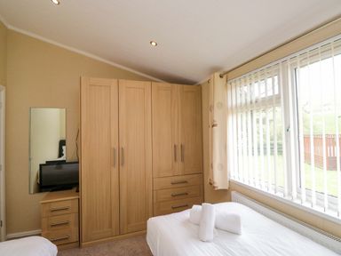 A bedroom with a wardrobe and television at Wansfell 2 Limefitt Park near Troutbeck