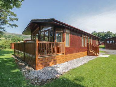 A lodge with decking and gravel path at Wally's Folly in Limefitt Park near Troutbeck