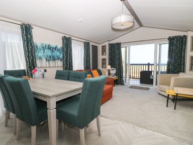 A living room with a table and chairs at Sand & Serenity in Bacton