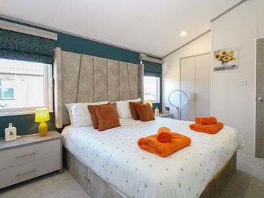 A bedroom with a bed and nightstand at Sand & Serenity in Bacton
