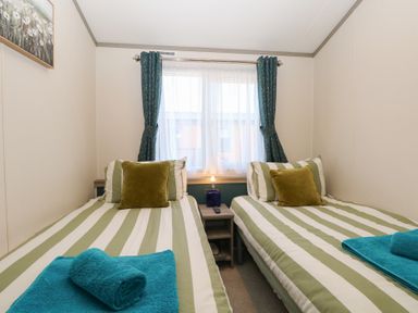 A bedroom with twin beds and a window at Sand & Serenity in Bacton