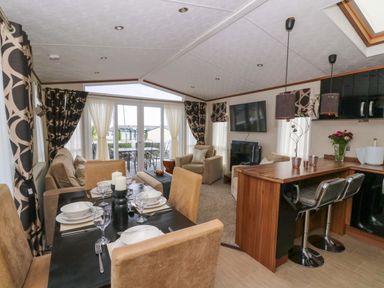 A living room with a dining area and kitchen counter at Ty Seren in New Quay