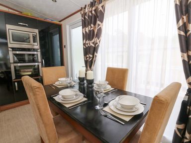 A dining room with a table set for four at Ty Seren, New Quay