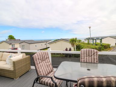 An outdoor area with a table and chairs overlooking other buildings at Ty Seren in New Quay