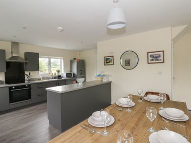 A kitchen with a dining table and chairs at Glandwr House in Crossgates near Llandrindod Wells