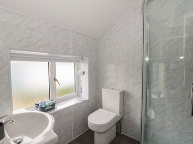 A bathroom with a shower, sink, and toilet at Glandwr House in Crossgates near Llandrindod Wells