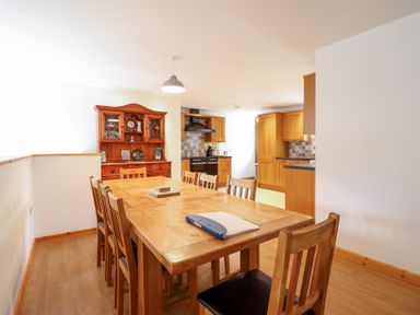 A kitchen with a dining table and sideboard at Gwernffridd