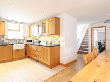 A kitchen with wooden cabinets and appliances at Gwernffridd