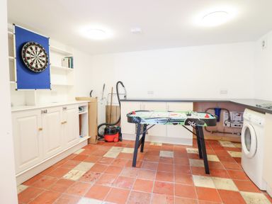 A utility room with a dartboard and game table at Gwernffridd
