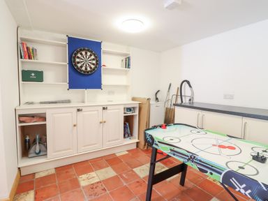 A games room with a dartboard and air hockey table at Gwernffridd