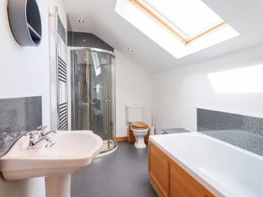 A bathroom with a sink, shower, bathtub, and toilet at Gwernffridd