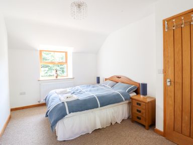A bedroom with a bed and window at Gwernffridd