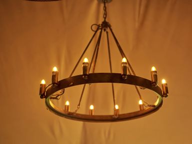 A circular chandelier with multiple small light bulbs hanging from the ceiling at Braeburn Lodge in Coxbridge near Glastonbury