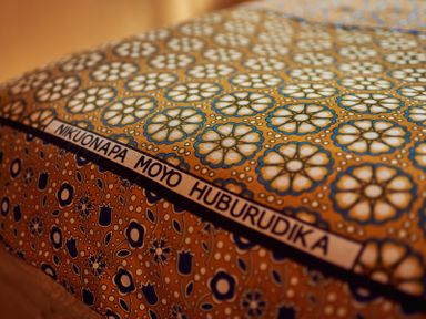 A close-up of a fabric with floral patterns and text in a different language