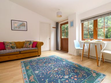 A living room with a sofa and a dining table at The Cow Shed in 