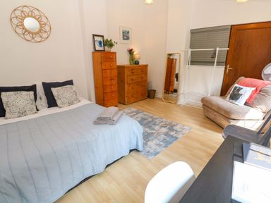 A bedroom with a bed and dresser at The Cow Shed 