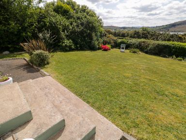 A garden with grass lawn steps shrubs flowers and distant hills at LOCH ILLION VIEW in Dungloe County Donegal