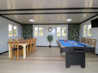 A game room with a billiards table and a wooden dining table with chairs at Barn Owl in Lode near Bottisham