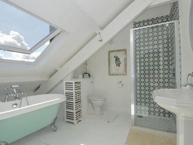 A bathroom with a bathtub, shower, toilet, and sink at Trenare in Truro
